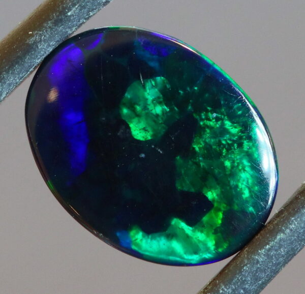 Blue and green flashing 1.46ct black Opal cabochon